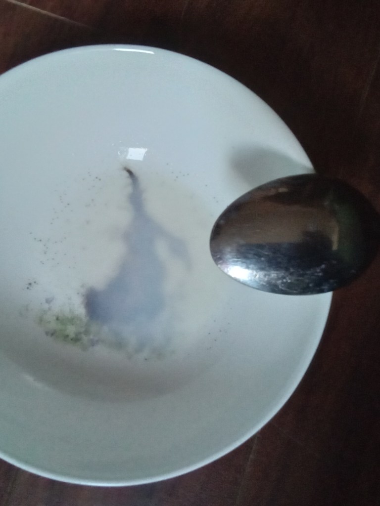 Un bol presque vide posé sur le sol, le fond est légèrement couvert de lait.