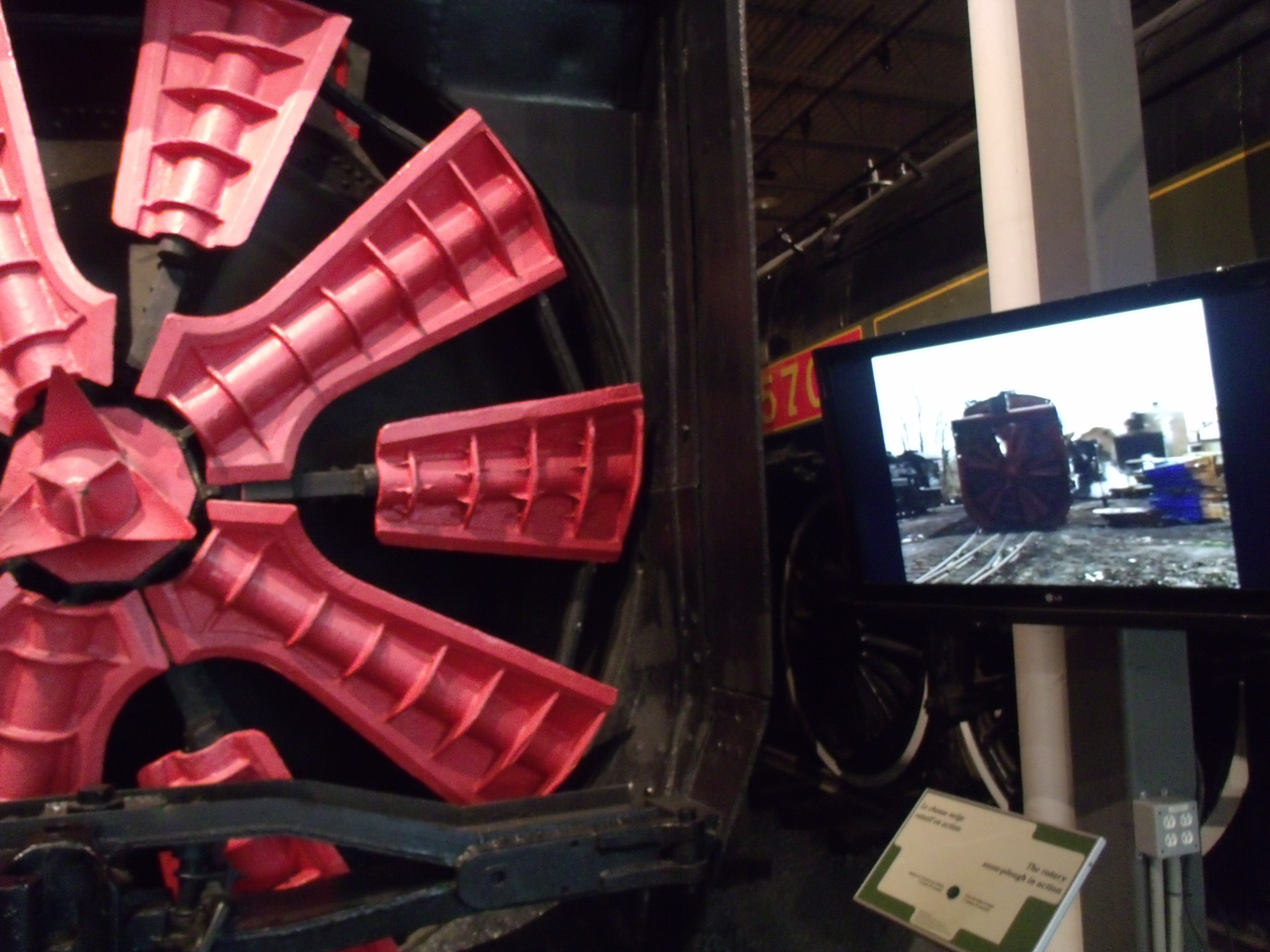 Vue partielle de la locomotive-souffeuse et du petit film la montrant en action.