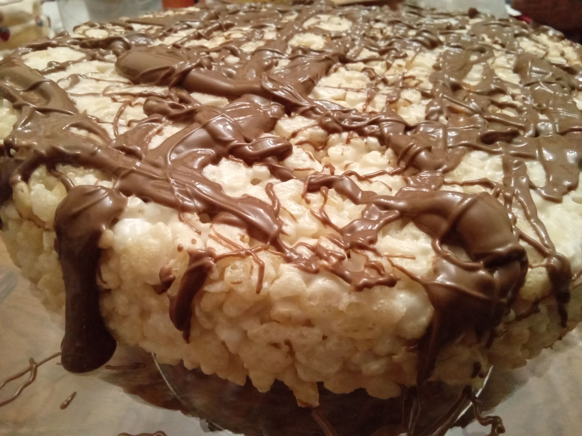 Gros plan sur un carré rond de Rice Crispies nappé de filets de chocolat